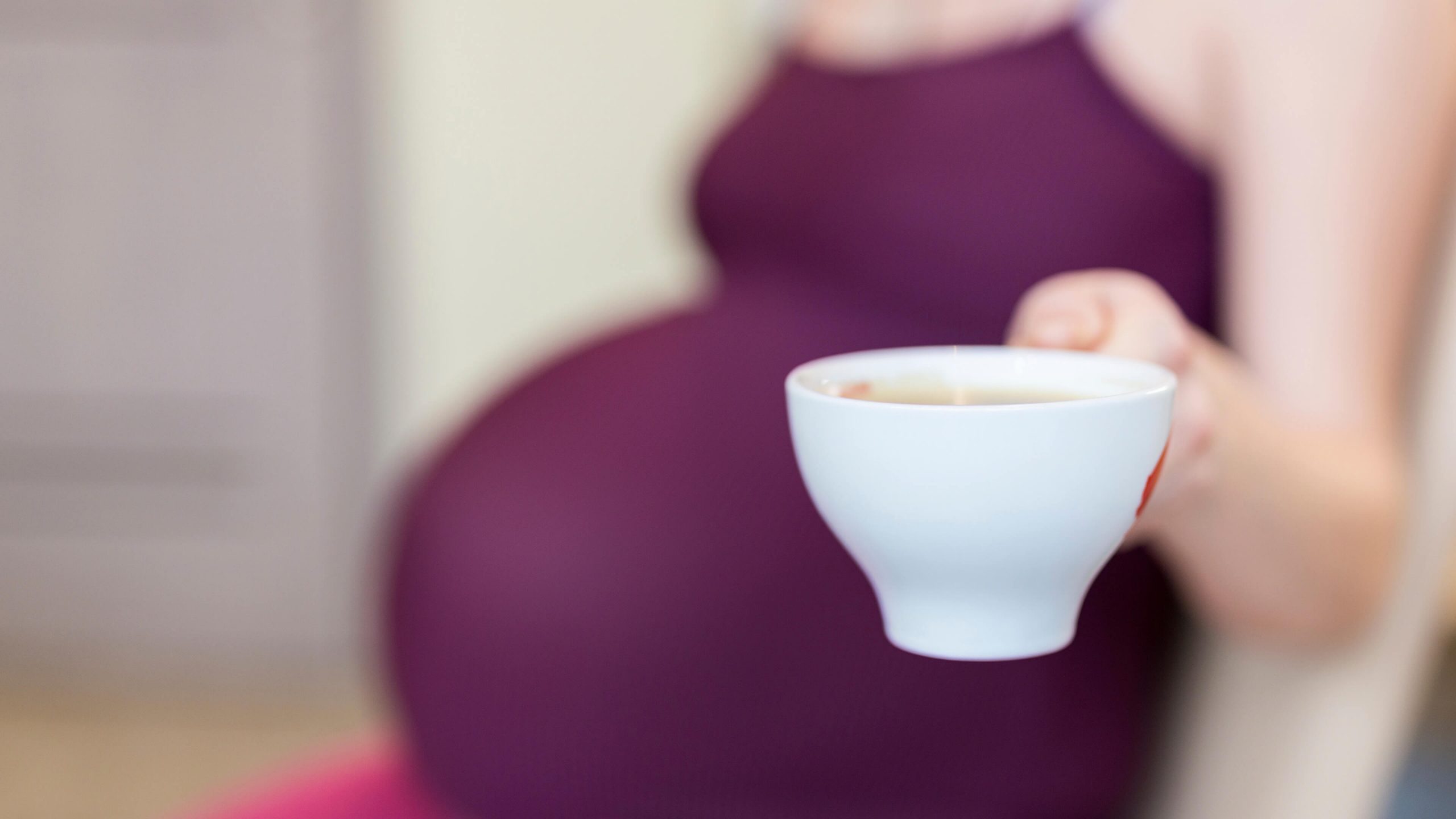 Donna incinta con tazza di caffè